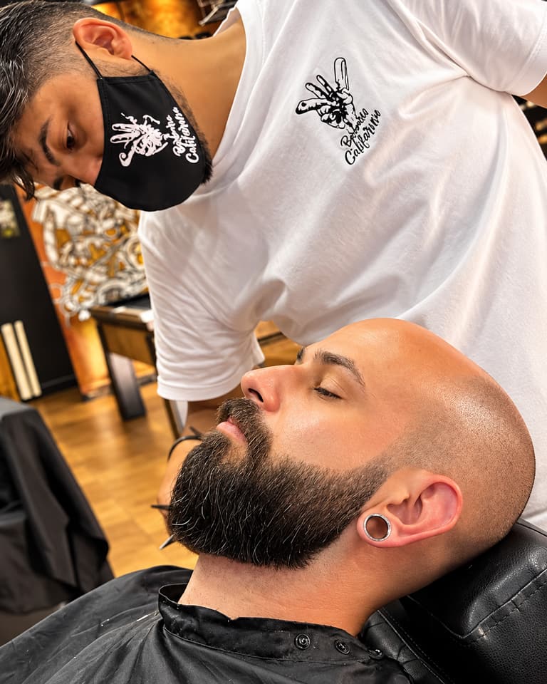 Cliente reclinado na cadeira com barba cheia e contorno alinhado