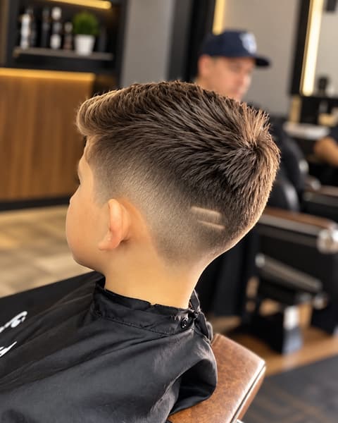 Menino com degradê na lateral, topo texturizado e dois riscos paralelos